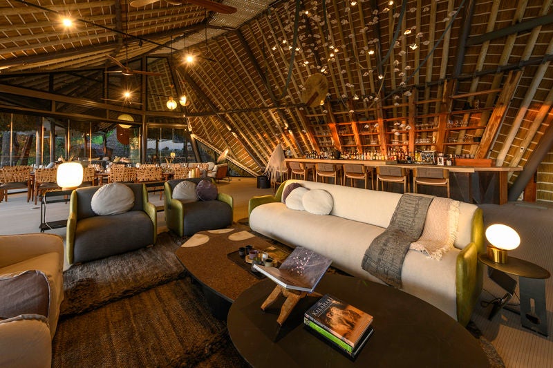 Elevated luxury tent suite at Wilderness Jao perched above Okavango Delta, with wooden deck and plunge pool overlooking savanna plains