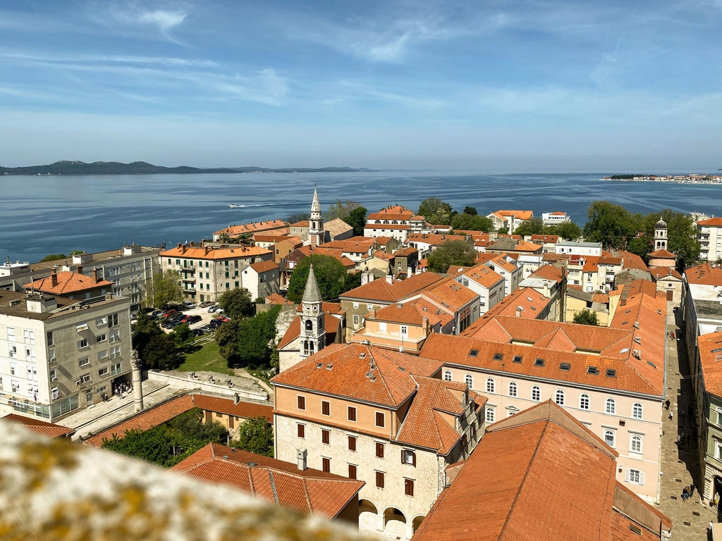 Elegant stone streets lined with historic Venetian architecture leading to St. Donat church, with Mediterranean sunlight illu