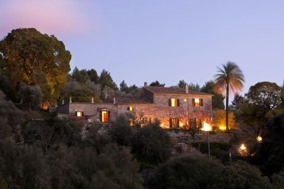 Luxurious stone hotel nestled in Valldemossa, Mallorca, with elegant terrace overlooking lush Mediterranean landscape and traditional Mallorcan architecture