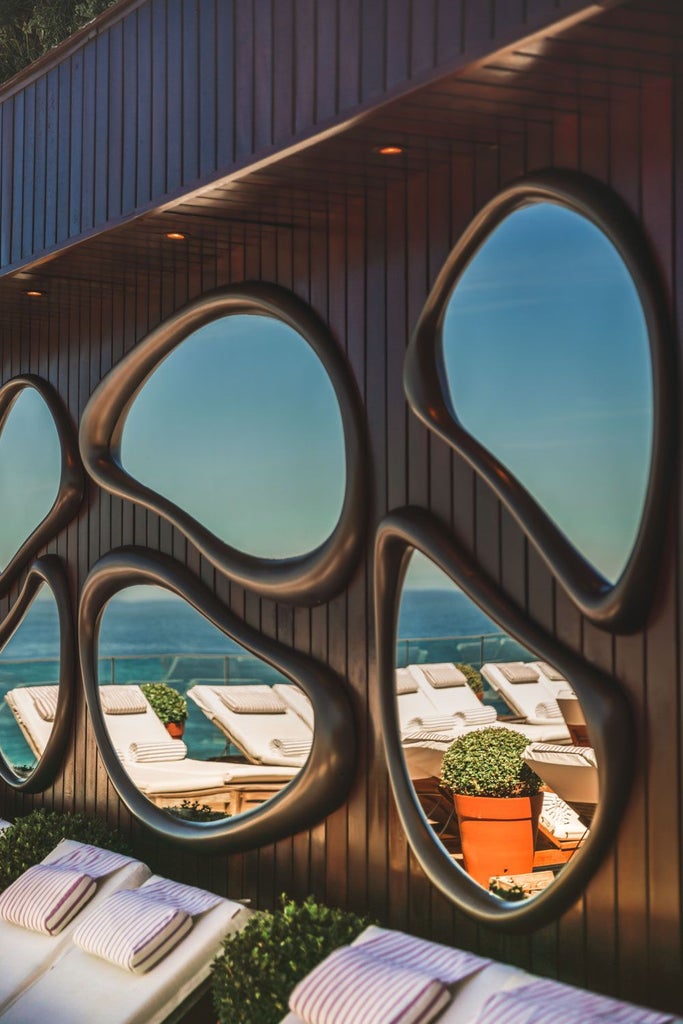 Luxurious rooftop infinity pool overlooking Ipanema Beach, with Art Deco-inspired Fasano Hotel silhouette against Rio de Janeiro's dramatic coastal landscape