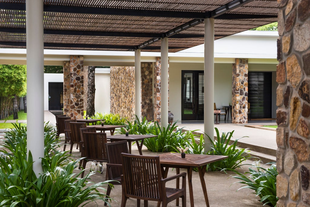 Serene luxury pool at Amansara resort, Siem Reap, with traditional Khmer architecture, lush gardens and private loungers in warm light