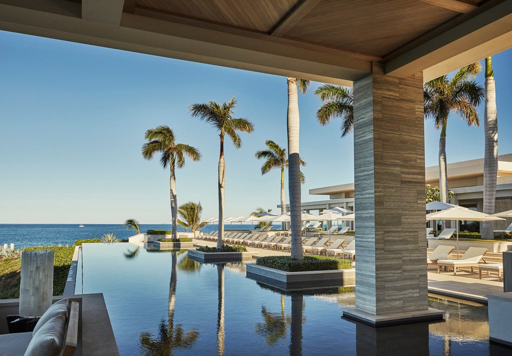 Modern oceanfront resort featuring infinity pools, private cabanas, and white minimalist architecture overlooking turquoise Caribbean waters