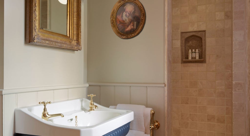 Elegant club double room at Batty Langley's boutique hotel, featuring plush dark blue velvet headboard, ornate classic decor, and refined period-inspired furnishings.