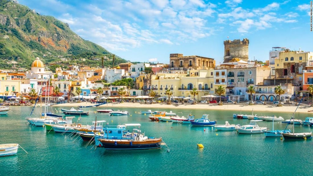 Elegant Mediterranean hotel perched on cliffside peninsula, with infinity pool overlooking turquoise sea and manicured gardens