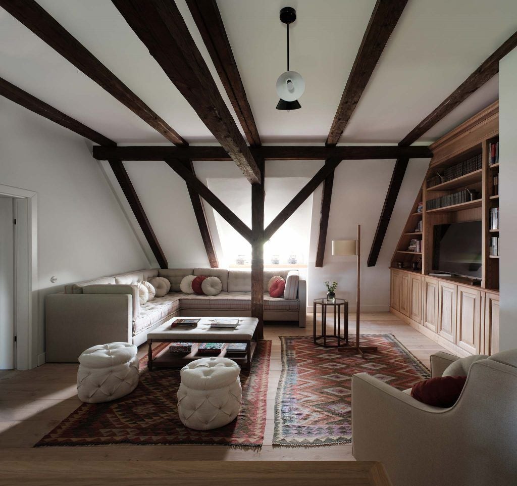 Rustic-luxe bedroom in Transylvanian Caretaker's House, featuring wooden beams, antique furnishings, and soft natural light filtering through traditional windows.