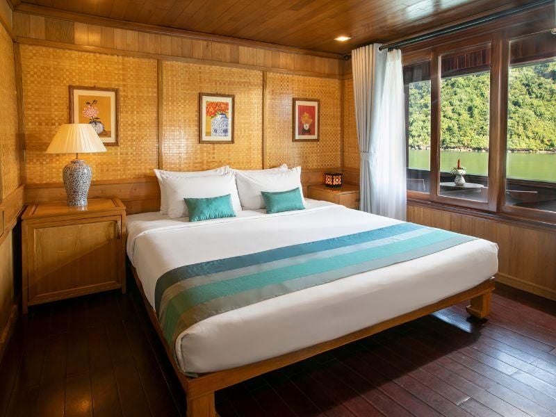 Luxurious Premium Balcony cabin on Bhaya Cruises, showcasing elegant wooden furnishings, panoramic windows, and sweeping views of Vietnam's scenic waters