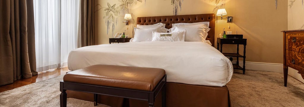 Luxurious marble-floored suite at Vidago Palace Hotel, Portugal, with elegant king bed, ornate gold-framed mirror, and soft neutral color palette