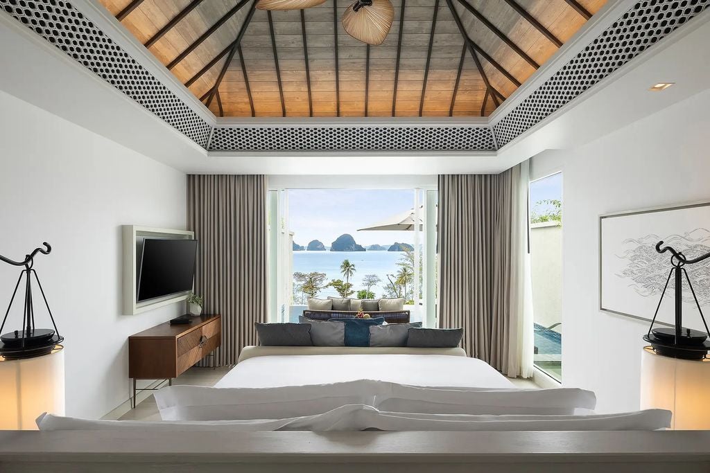 Luxurious king suite with private infinity pool overlooking Andaman Sea, featuring modern Thai decor and floor-to-ceiling windows