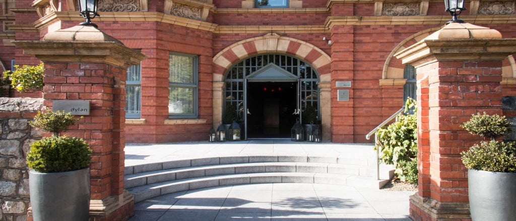 Elegant boutique hotel exterior with classic Georgian architecture, warm stone facade, and pristine landscaped entrance in Dublin city center