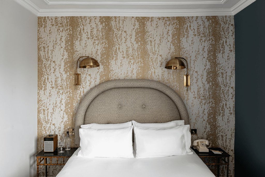 Elegant boutique hotel room in Paris with plush bedding, vintage-inspired decor, soft neutral color palette, and sophisticated French styling