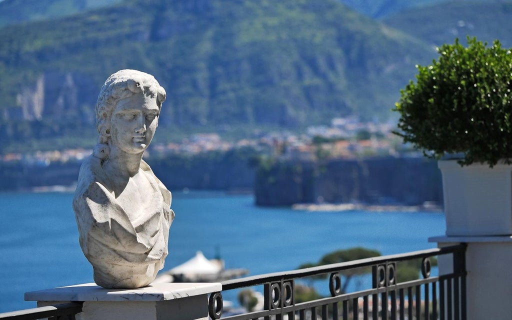 Luxurious cliffside hotel overlooking the azure waters of the Amalfi Coast, featuring elegant Mediterranean architecture with pristine white walls and arched windows