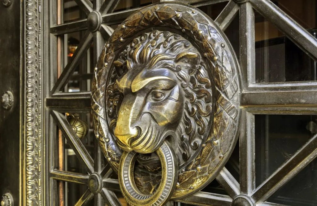 Luxurious Art Nouveau facade of Grand Hotel Central in Barcelona, with elegant golden details and ornate balconies overlooking a historic Spanish street at sunset