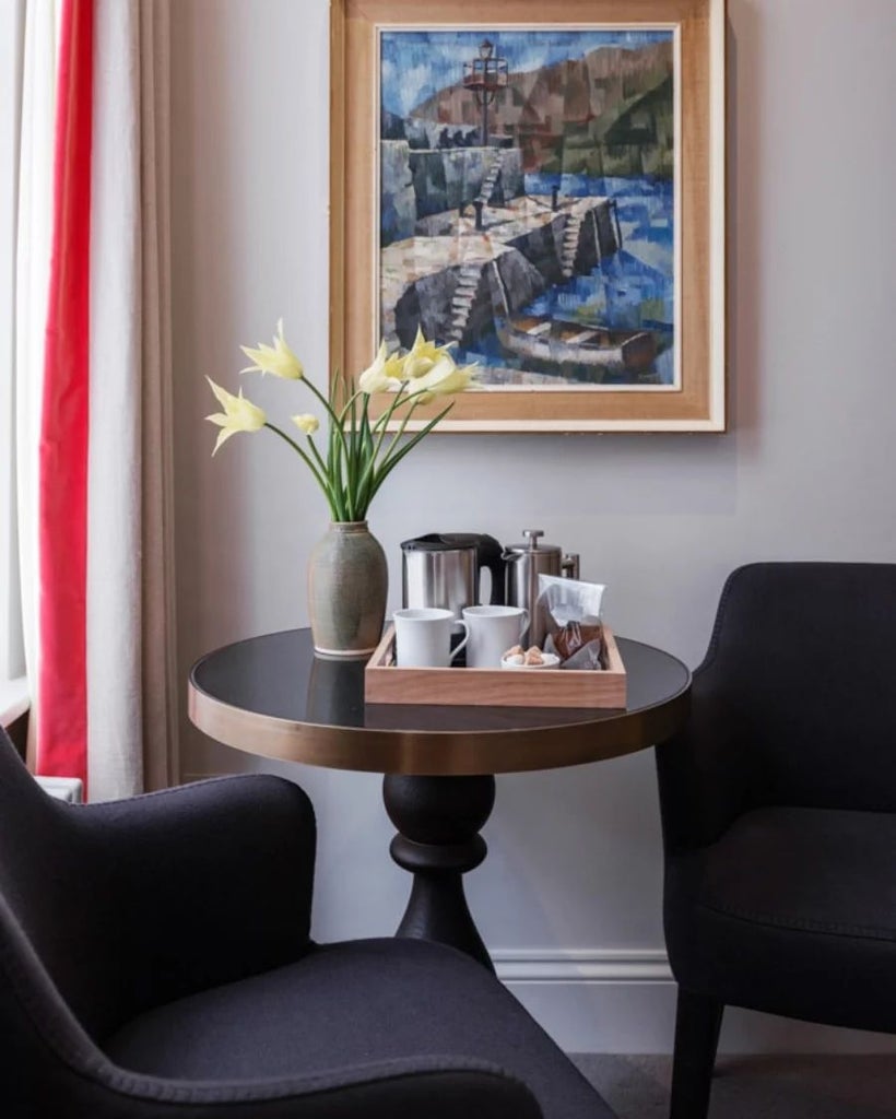 Elegant accessible hotel room with soft neutral tones, plush bedding, modern accessibility features, and sophisticated minimalist design in historic United Kingdom setting