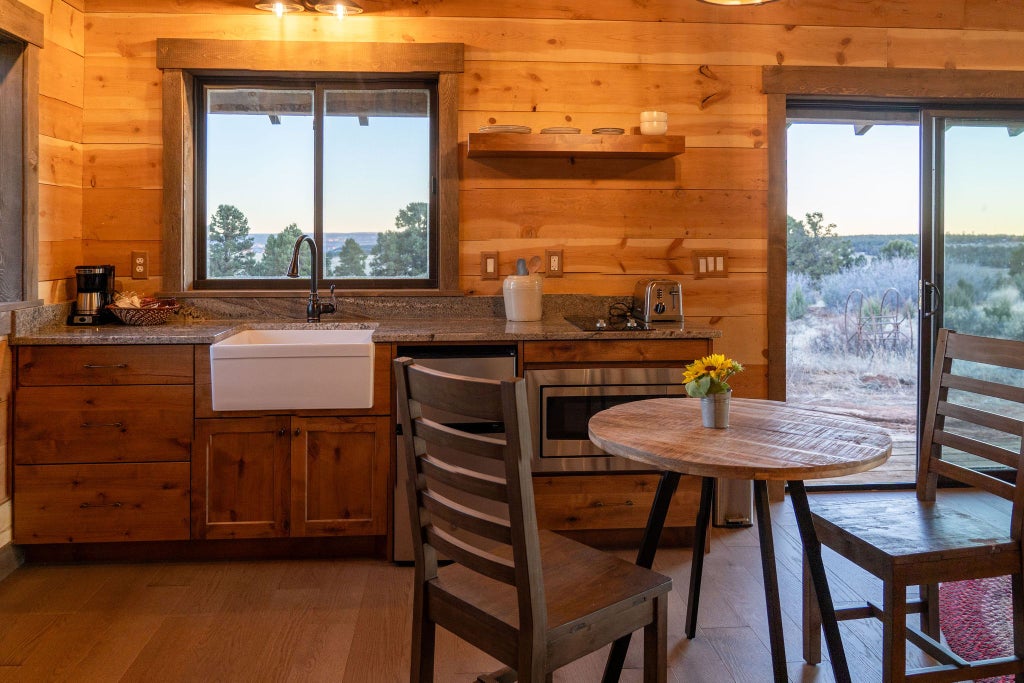 Rustic wooden lodge room with plush bedding, scenic mountain views, and warm earth-toned decor showcasing comfortable western-style accommodations at scenset Mountain Ranch