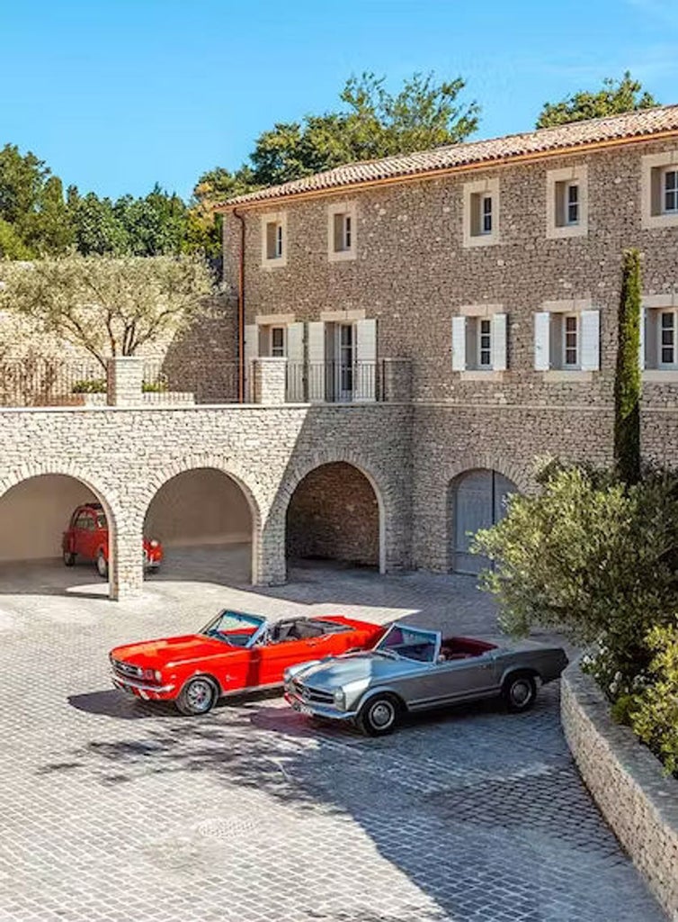 Elegant stone hotel nestled on hillside in Provence, with cascading terraces, classical French gardens and panoramic valley views