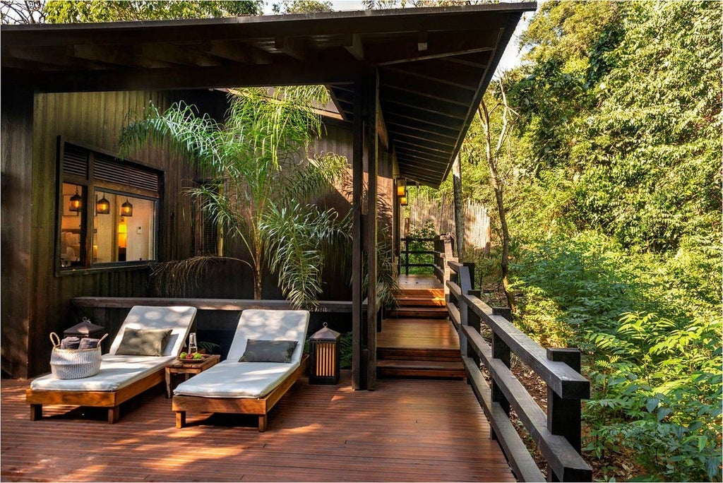 Luxurious wooden villa elevated on stilts in lush rainforest, featuring private deck and panoramic jungle views at Awasi Iguazu