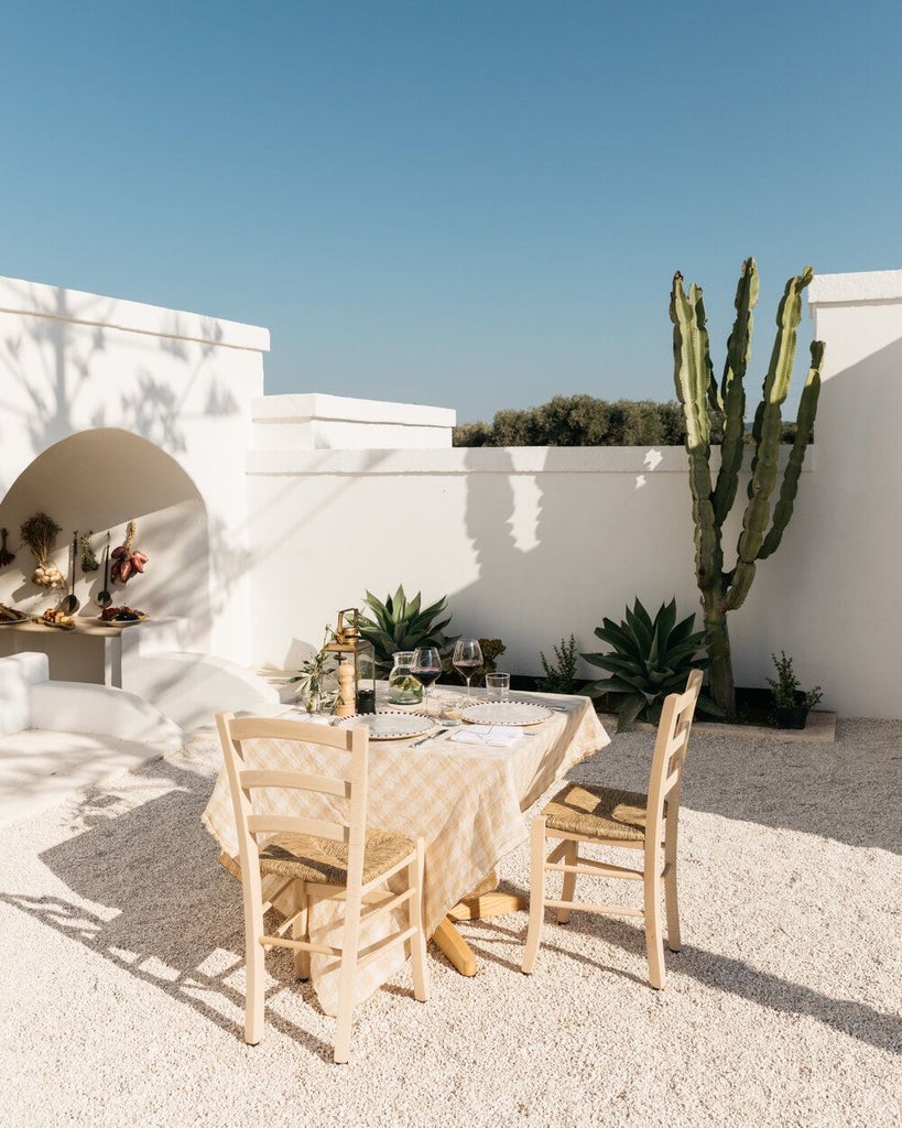 Rustic stone villa nestled in Puglia's countryside, surrounded by olive groves, with sun-drenched terracotta walls and an elegant Mediterranean poolside setting