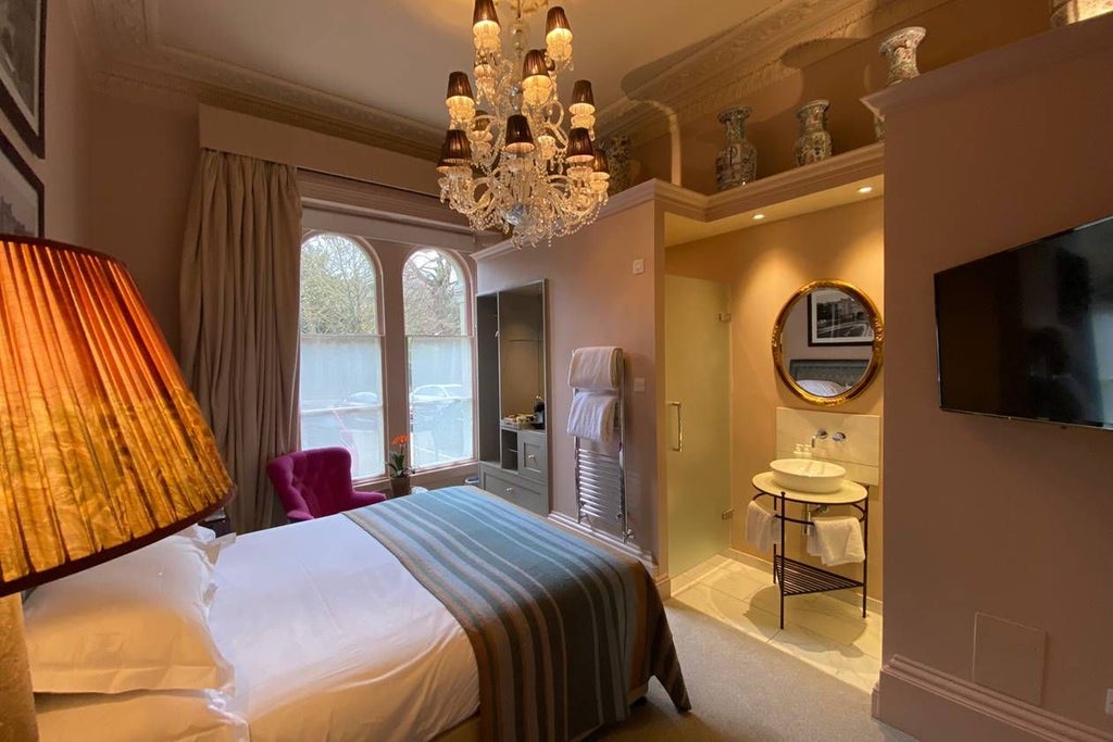 Luxurious king room with elegant bird-themed decor, soft neutral tones, plush bedding, and sophisticated contemporary design in a UK boutique hotel setting