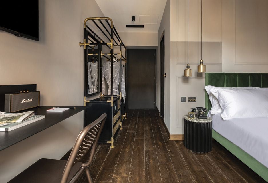 Elegant modern hotel room with minimalist design, crisp white linens, soft neutral tones, and sleek contemporary furnishings in Chapter Roma, Italy