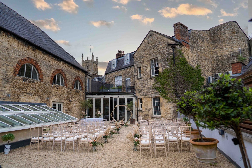 Elegant stone-facade historic hotel nestled in picturesque UK countryside, featuring classic British architectural charm and inviting exterior with warm lighting