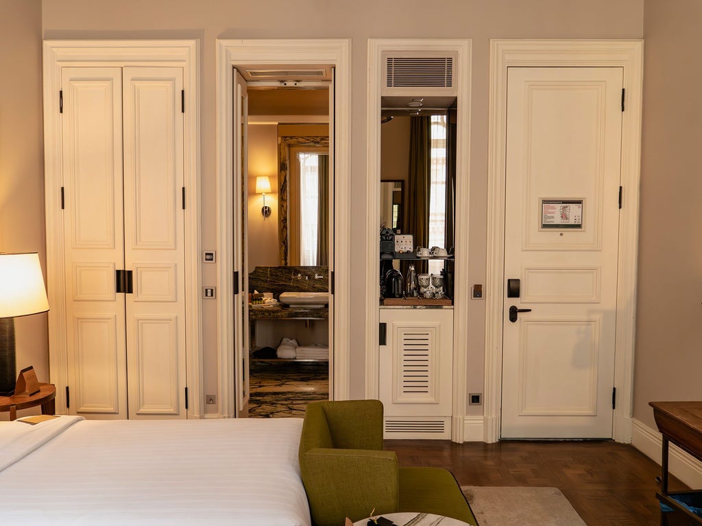 Elegant deluxe twin hotel room with plush white beds, rich wooden furnishings, and sophisticated neutral color palette in historic Istanbul boutique hotel