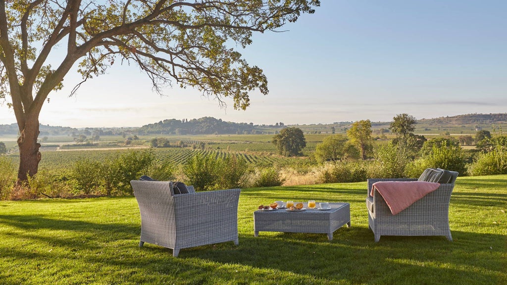 Luxurious French château hotel nestled in lush vineyards, featuring elegant stone architecture, manicured gardens, and golden sunset light casting warm tones