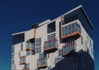 Modern luxury hotel with sleek glass facade, set against dramatic Bolivian mountain landscape, contemporary architectural design blending urban sophistication with natural scenery