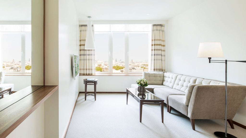 Elegant COMO Suite with city views, featuring luxurious king bed, contemporary design, soft neutral tones, and sleek minimalist furnishings in metropolitan London