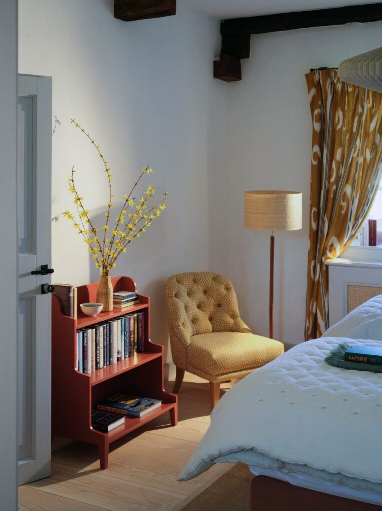 Rustic luxury barn corner suite at Bethlen Estates, featuring rich wooden beams, plush white bedding, and traditional Transylvanian architectural details bathed in soft natural light.