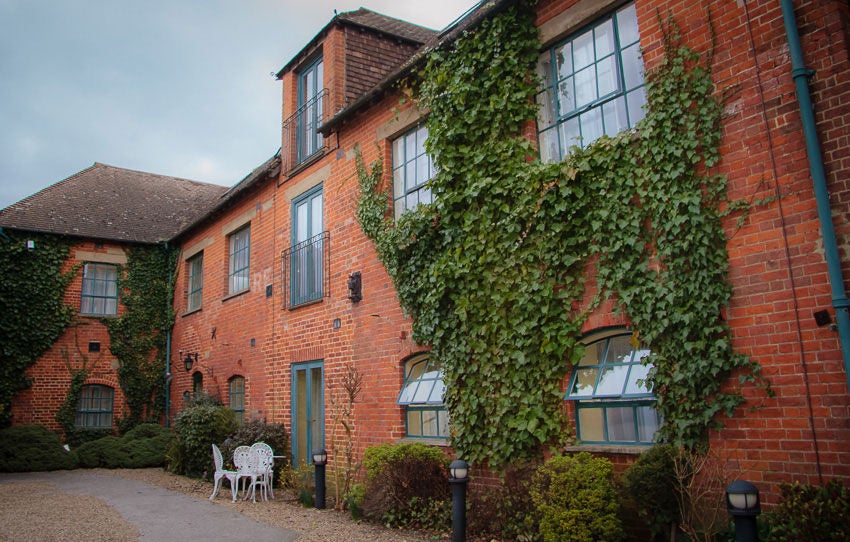 Historic stone-built luxury hotel in UK featuring Victorian architecture, elegant bay windows, and manicured front gardens with paved entrance