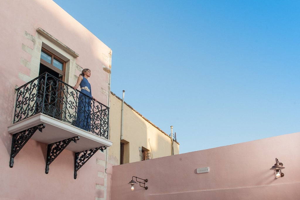 Elegant white boutique hotel nestled in Santorini's cliffside, featuring pristine architecture, azure blue domes, and breathtaking Aegean Sea panorama