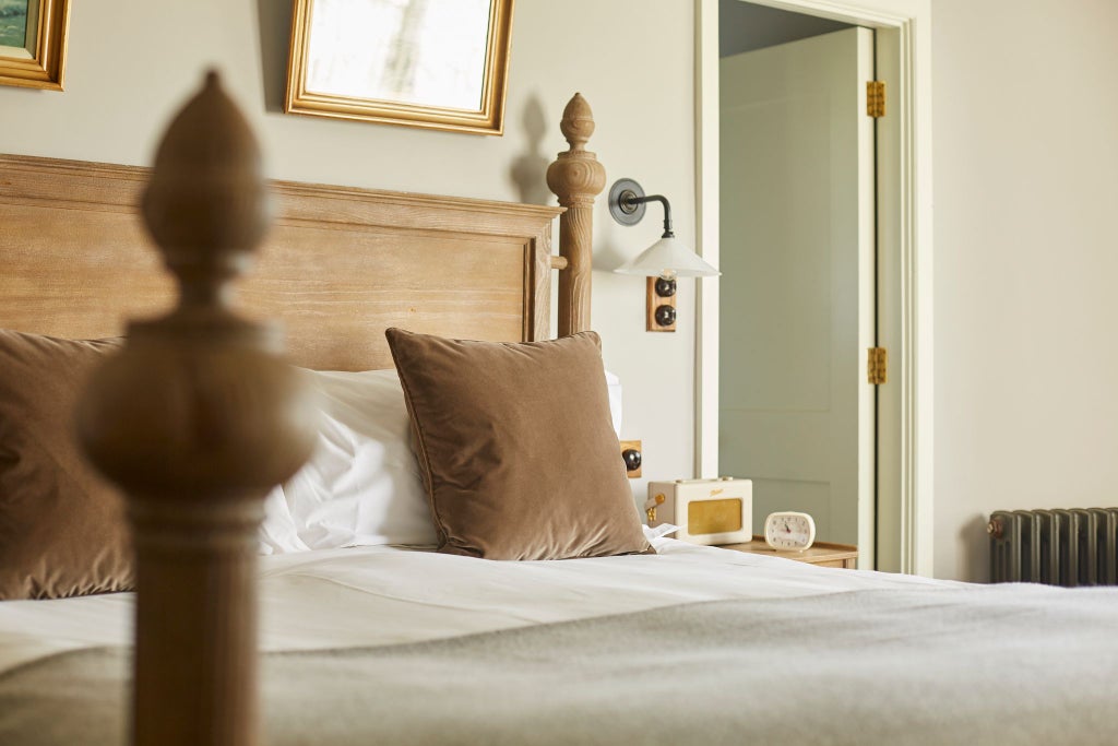 Coastal luxe hotel room with plush king bed, vintage maritime decor, soft natural light, seaside color palette, and rustic-chic furnishings at scenset seaside retreat