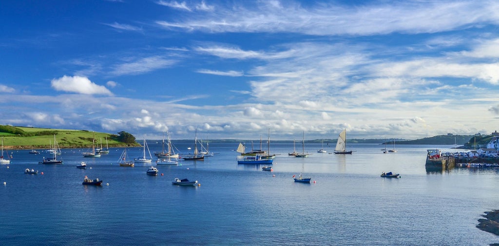 Luxury coastal boutique hotel with ocean views, white-washed exterior, positioned on scenic Cornwall coastline with elegant maritime design elements