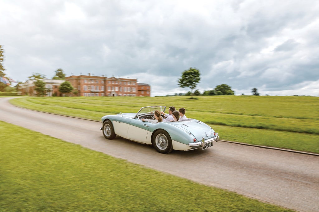 Elegant Georgian manor hotel nestled in Hampshire countryside, featuring manicured gardens, stone facade and ornate windows