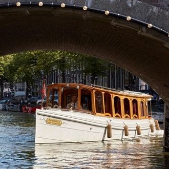 Historic luxury hotel Pulitzer Amsterdam with elegant brick facade, tall windows and traditional Dutch architecture along scenic canal