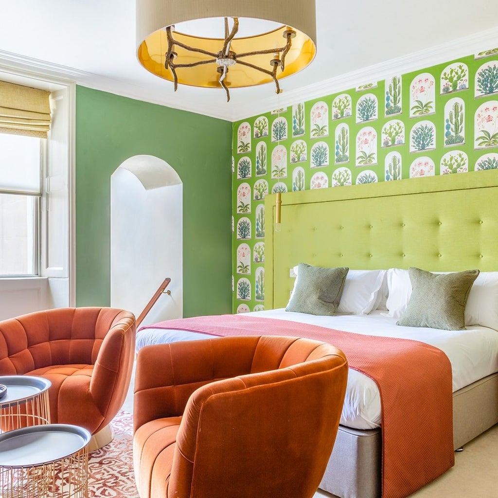 Elegant deluxe hotel room with plush king-sized bed, soft neutral tones, modern minimalist decor, and large windows at The Queensberry Hotel, United Kingdom