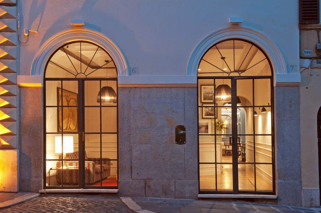 Elegant boutique hotel exterior with white facade, wrought iron balconies, and lush greenery in a charming Roman neighborhood