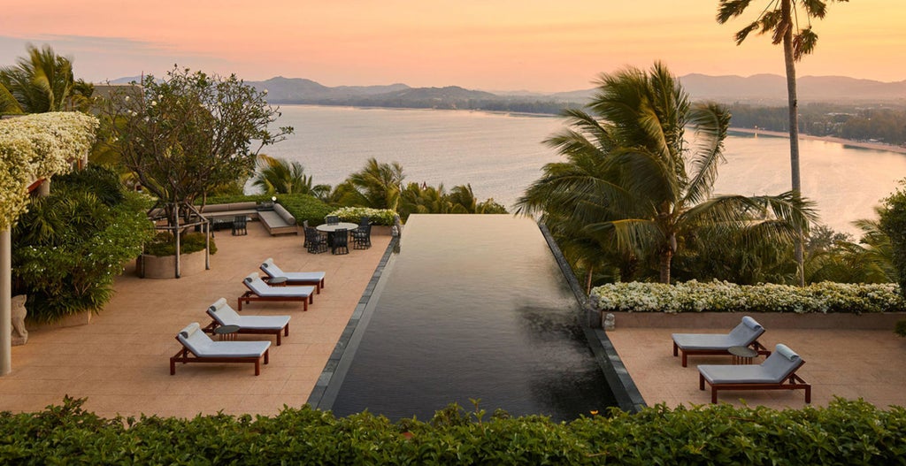 Spacious oceanfront villa bedroom with floor-to-ceiling windows, elegant Thai decor, private terrace, and panoramic Andaman Sea views