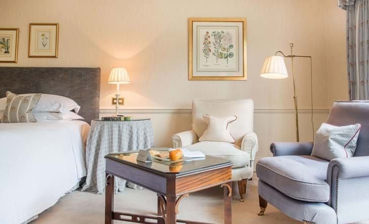 Elegant classic room at Chewton Glen Hotel & Spa, featuring plush white bedding, soft neutral tones, and refined traditional British countryside decor