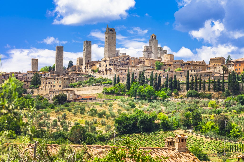 Medieval towers of San Gimignano rise above Tuscan countryside while elegant Siena's Romanesque cathedral stands in golden sunlight