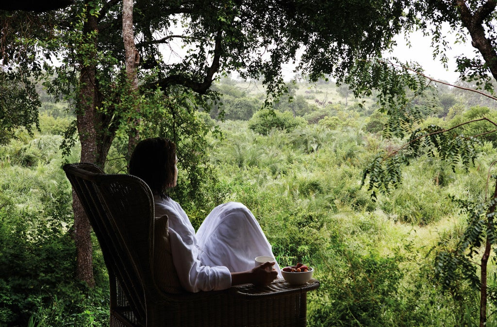 Elevated luxury treehouse suite with private deck overlooking African savanna, featuring natural wood and canvas design elements