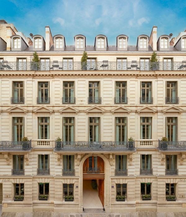 Elegant white facade of Hotel Maison Delano Paris featuring ornate French architecture, wrought-iron balconies, and classic Haussmann windows