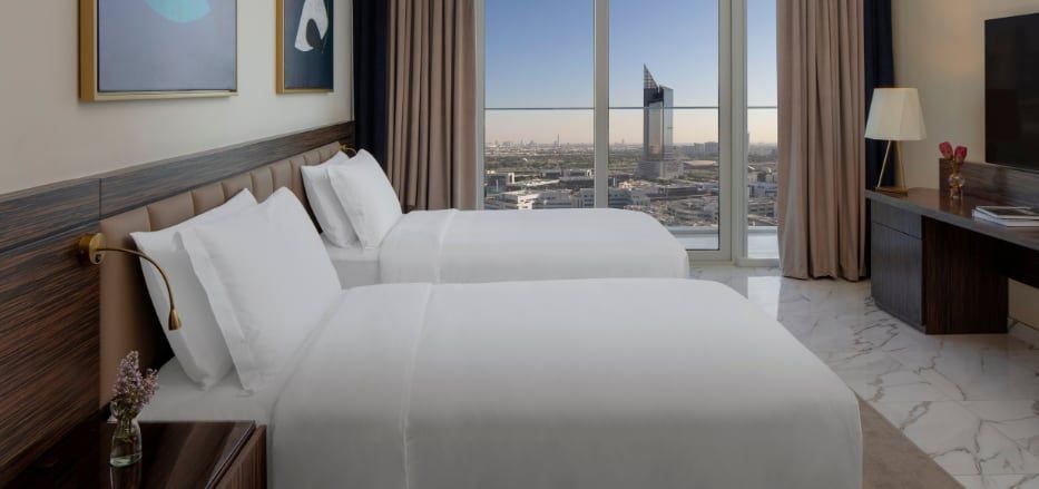 Modern Dubai hotel studio with city skyline view, featuring sleek contemporary furnishings, large windows, and elegant neutral color palette showcasing urban luxury