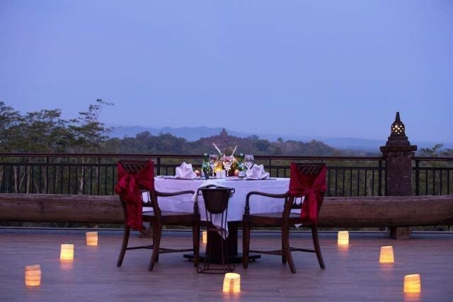 Luxurious infinity pool overlooking lush jungle and misty mountains at Plataran Borobudur resort, with traditional Javanese architecture