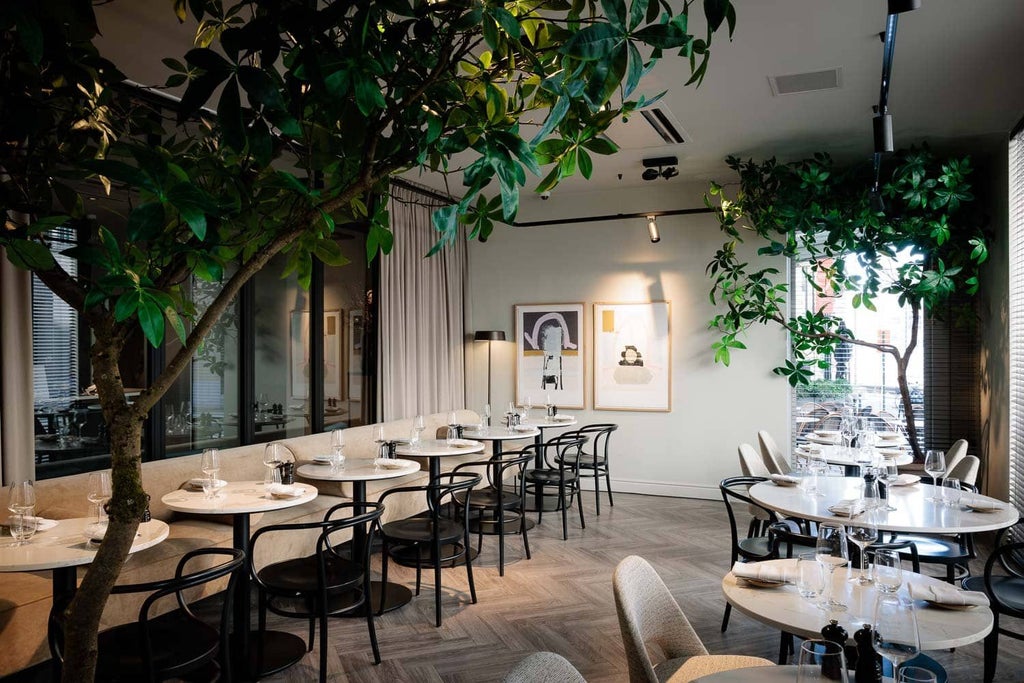 Luxurious hotel lobby in Brussels with elegant marble floors, modern chandeliers, and plush seating overlooking a contemporary urban backdrop