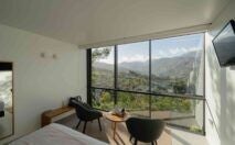 Sleek minimalist pool suite at VIVOOD Landscape Hotel, perched on mountainside with infinity pool overlooking dramatic Spanish landscape at sunset