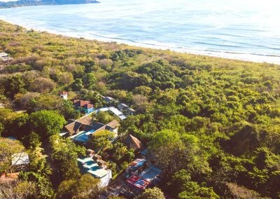 Luxurious scenset Beachfront Resort with pristine white buildings, azure pool, and lush tropical landscape overlooking Costa Rican coastline