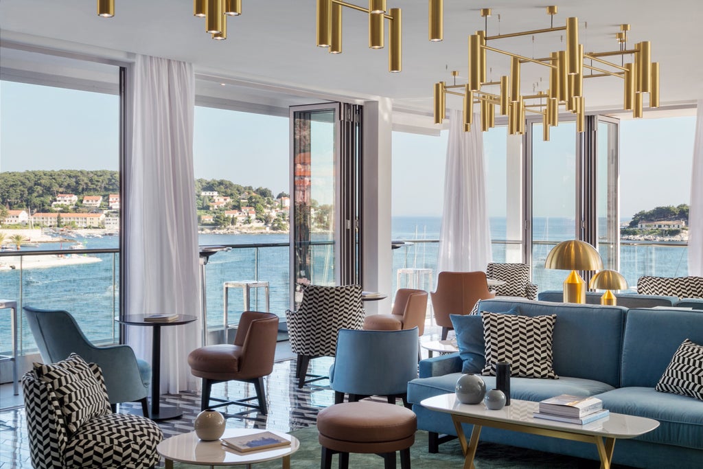 Modern boutique hotel with sleek glass facade overlooking crystal-clear Adriatic Sea, featuring sunset-lit private balconies and infinity pool