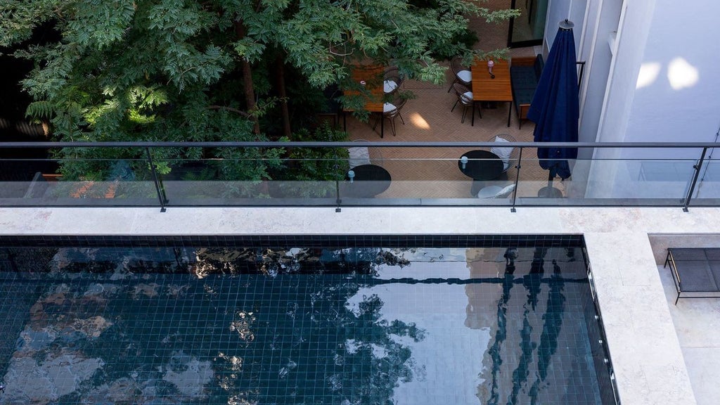 Elegant boutique hotel facade with white exterior, lush garden, and classic Portuguese architectural details in Lisbon's historic neighborhood