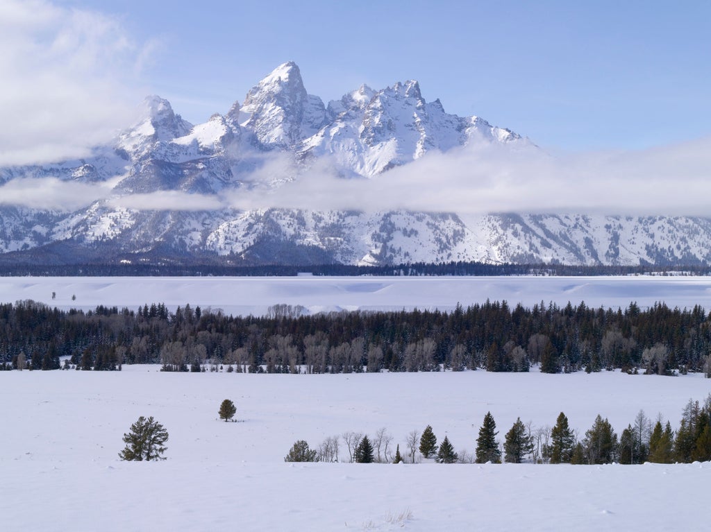 Luxurious mountain resort Amangani with infinity pool overlooking snow-capped Grand Tetons and pristine Wyoming valley at sunset